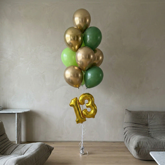 Bunch of green and gold balloons with a number 13 balloon in a living room setting.