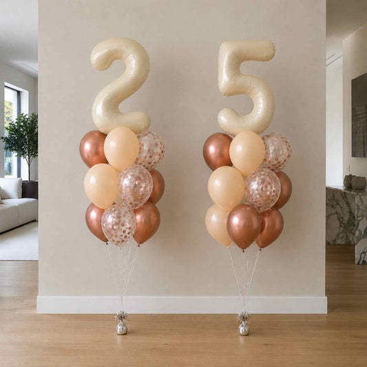 Two balloon arrangements with the number '25' in a living room setting.