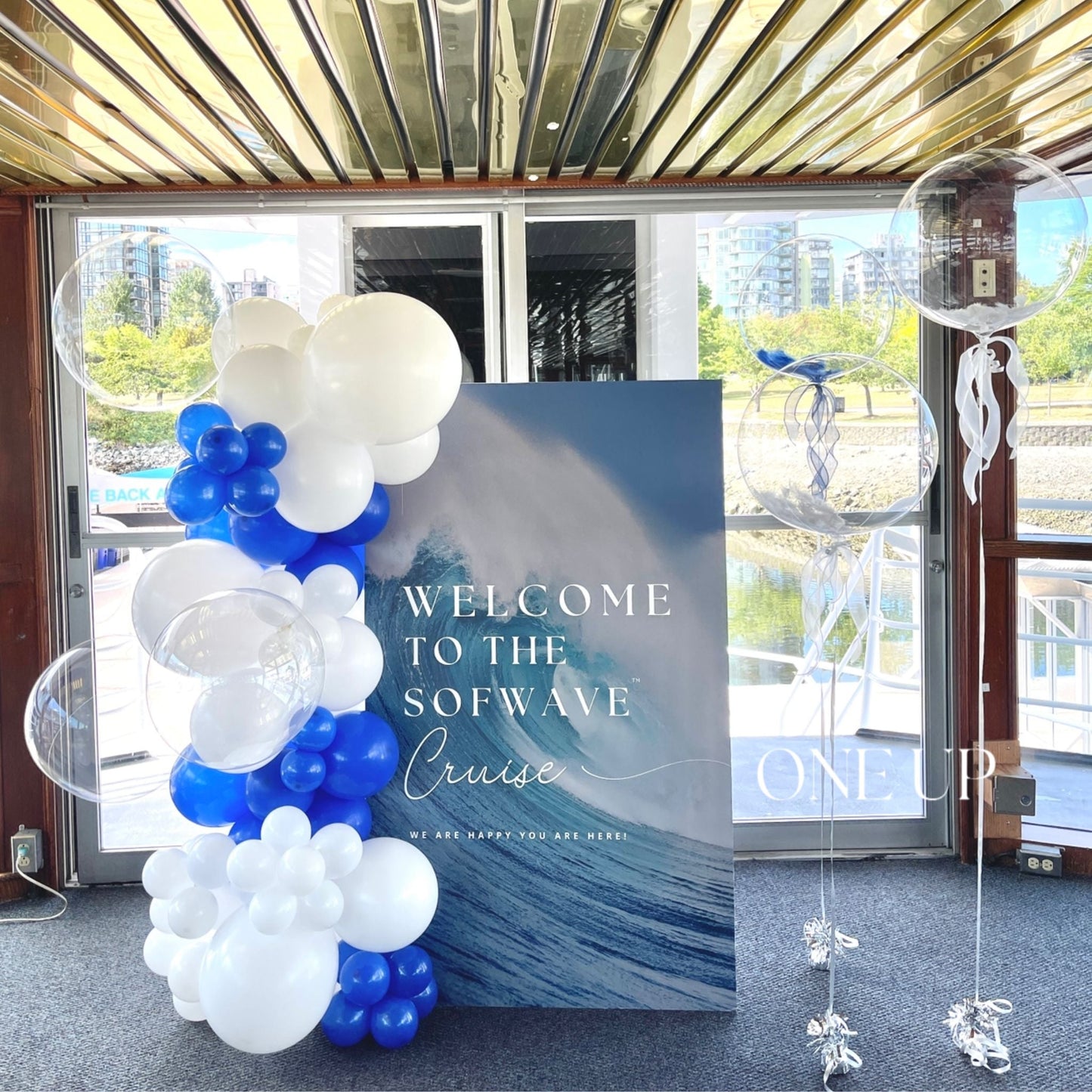 A custom backdrop with a balloon garland and three clear bubble balloons in an indoor setting.