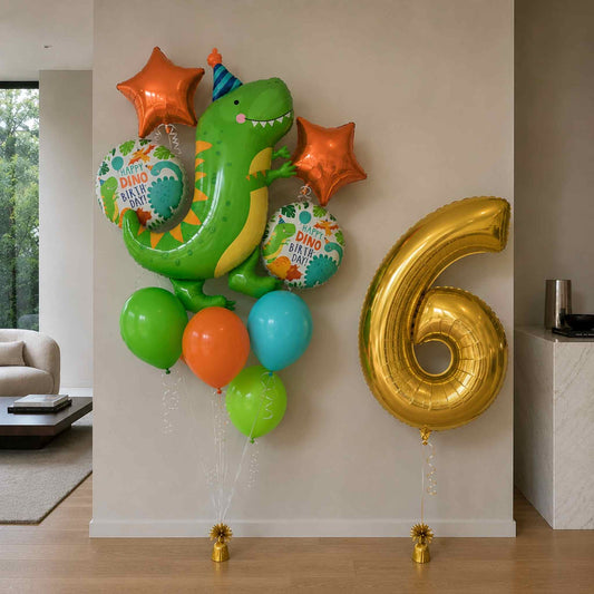 A set of dinosaur-themed birthday balloons, including a green T-Rex, orange star balloons, teal and light blue round balloons, and a large metallic gold number 6 balloon, displayed against a beige wall in a modern living room setting.