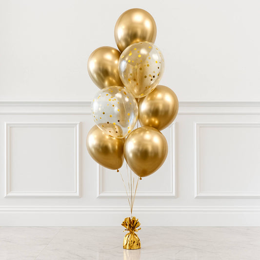 Bouquet of gold and clear balloons with gold confetti against a white wall.