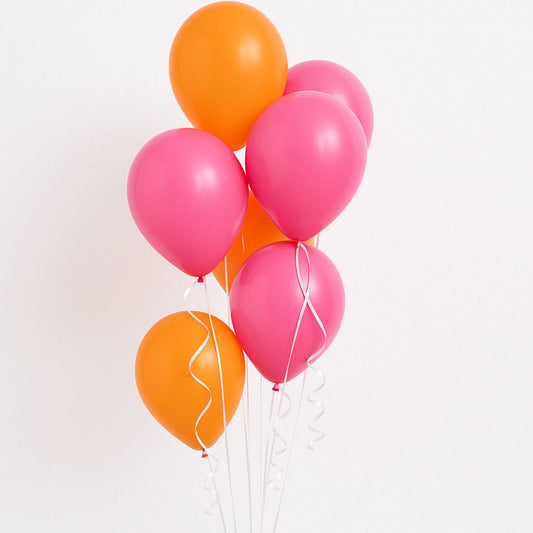Pink and orange balloons on a light pink background