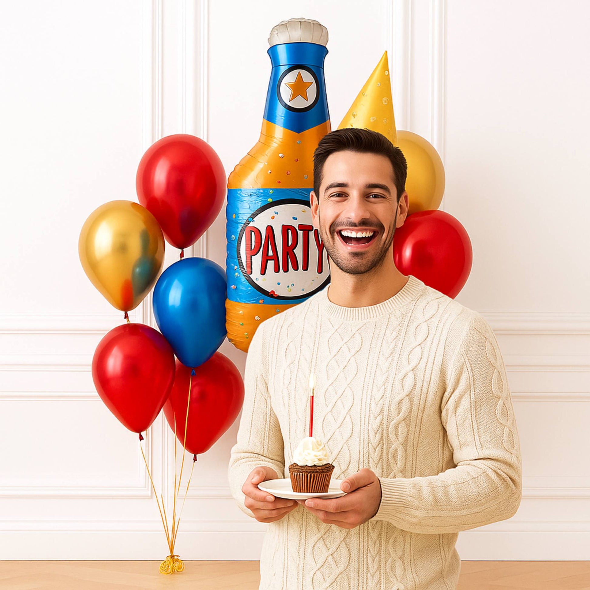 Man holding a cupcake with colorful balloons and a large party popper in the background.