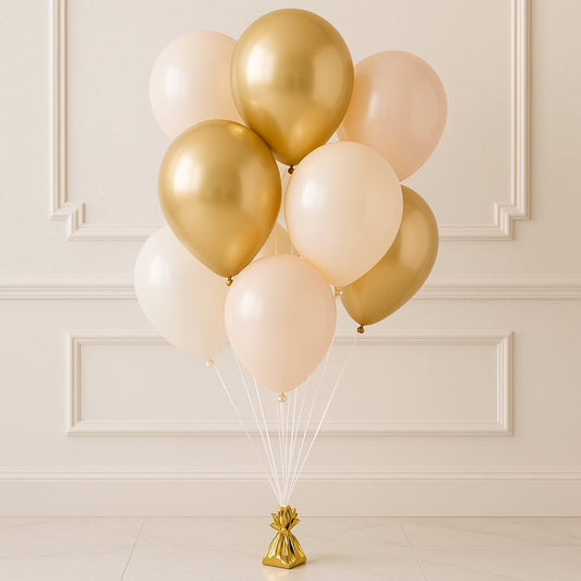 Bouquet of gold, white, and pink balloons against a beige wall.