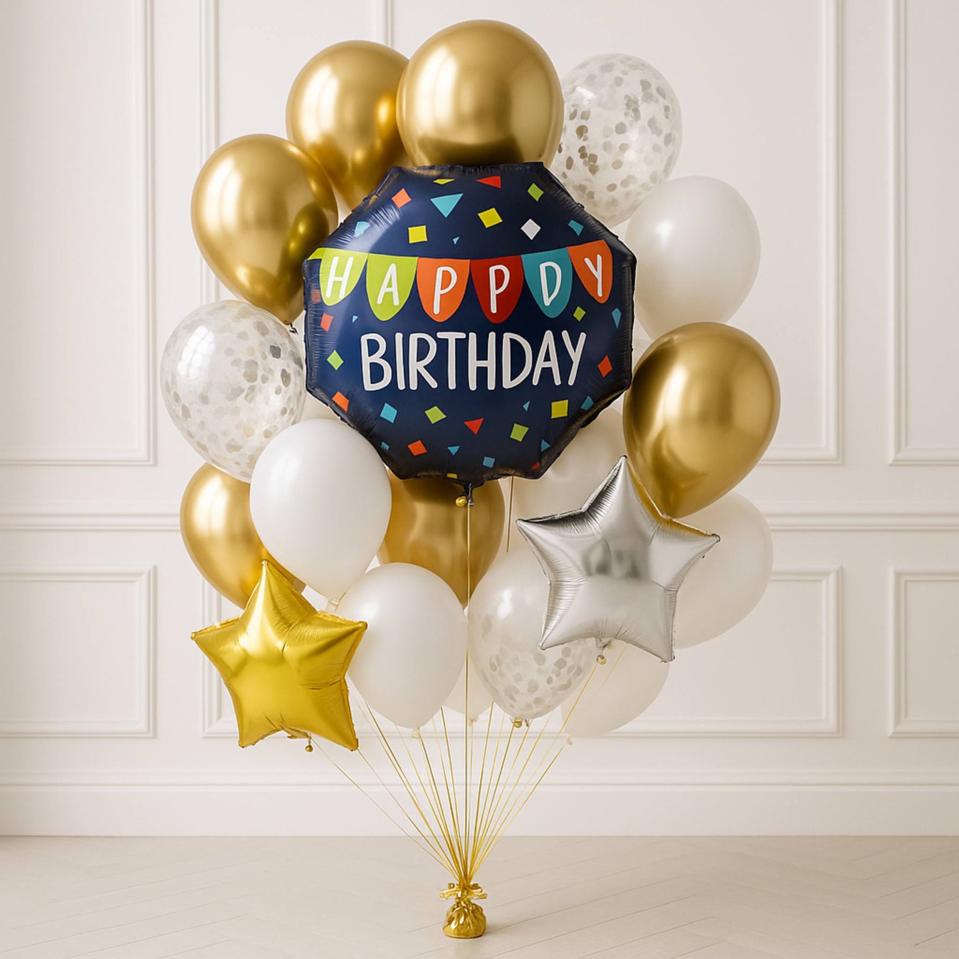 Balloon bouquet with a 'Happy Birthday' balloon against a white paneled wall.