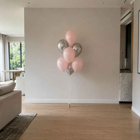 Bunch of pink and silver balloons in a living room setting
