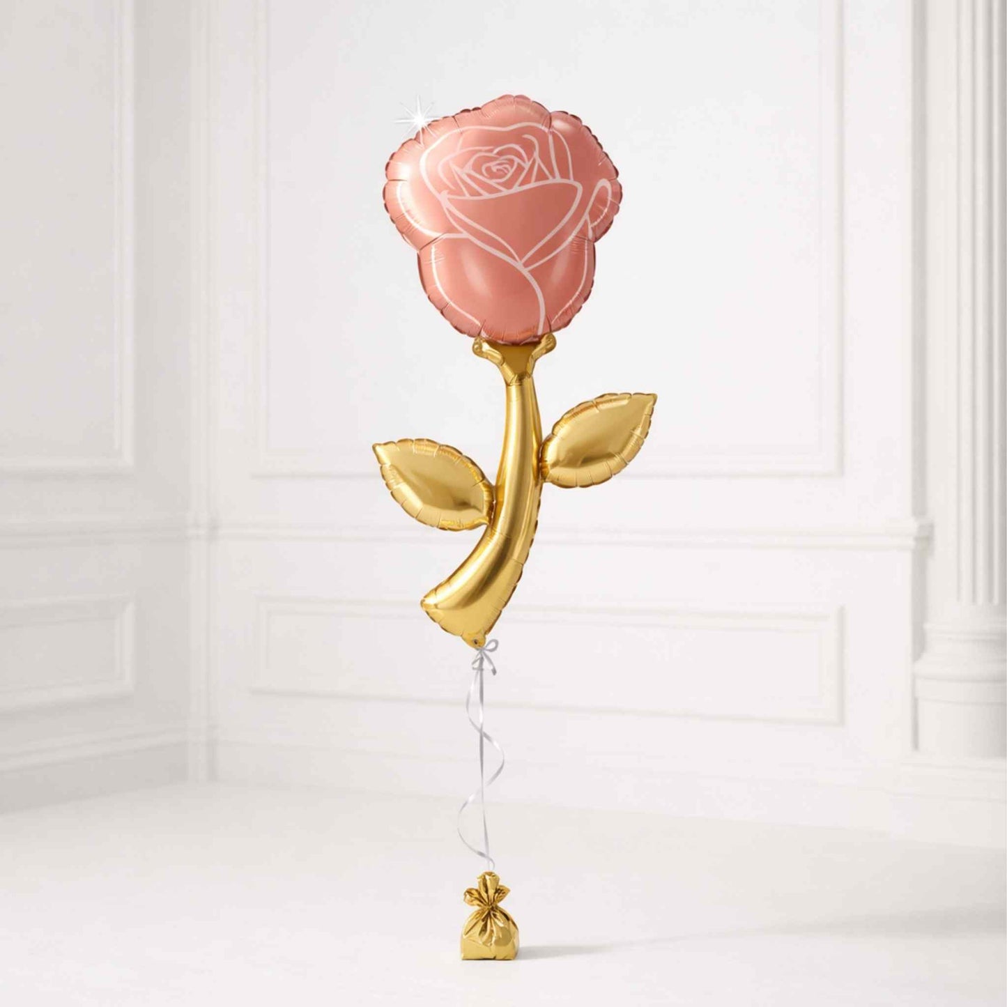 Pink rose-shaped balloon with gold stem and leaves on a white background