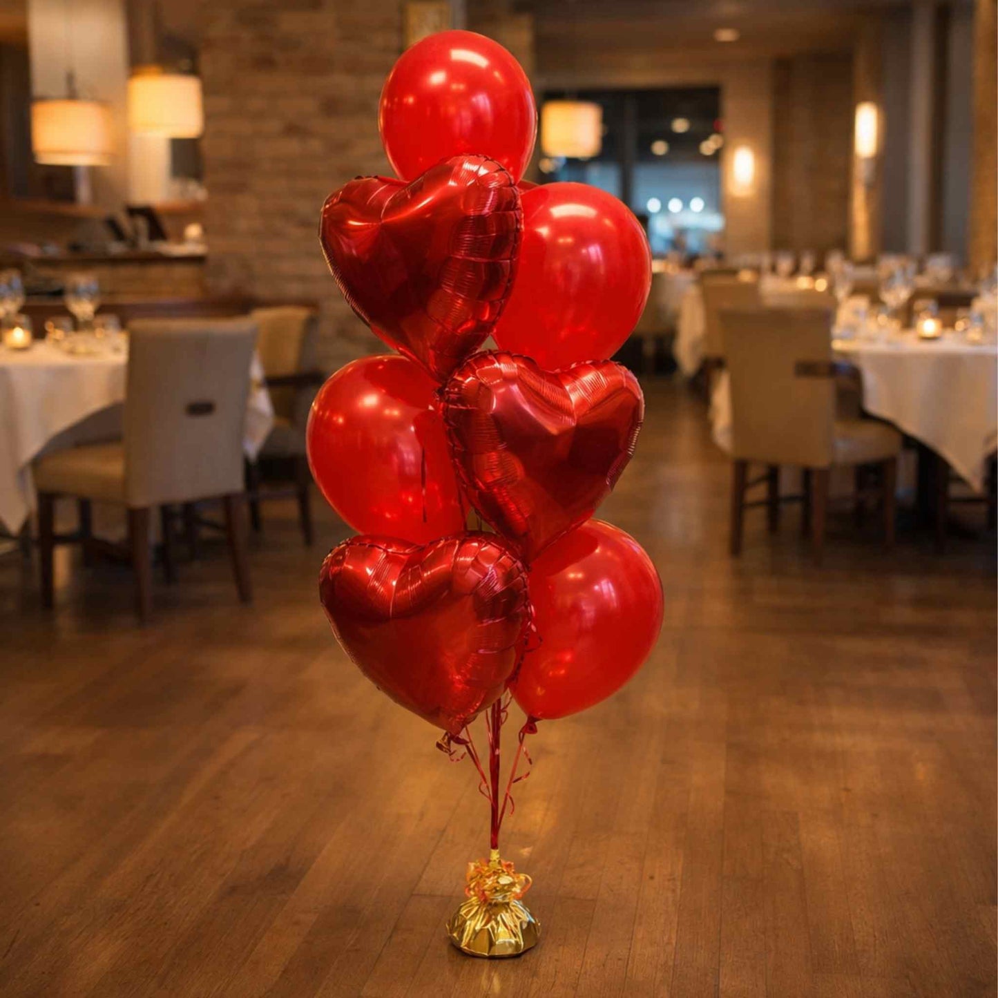 Red heart-shaped balloons on a wooden floor with a restaurant setting in the background