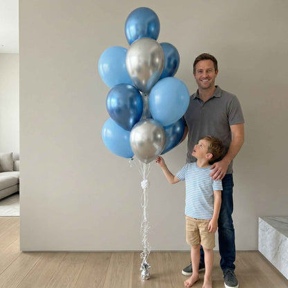 Man and child holding blue and silver balloons indoors