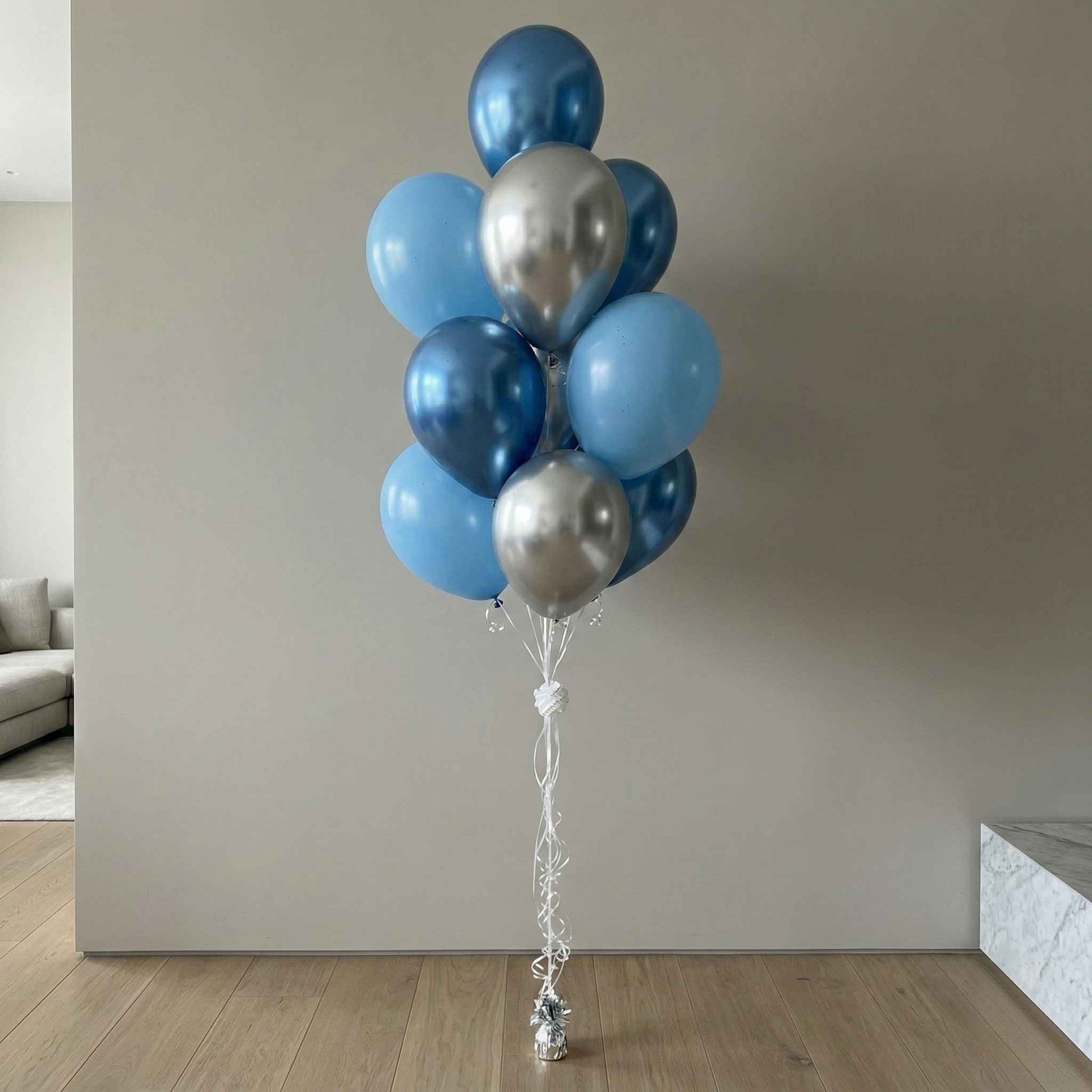 Bouquet of blue and silver balloons in a modern indoor setting