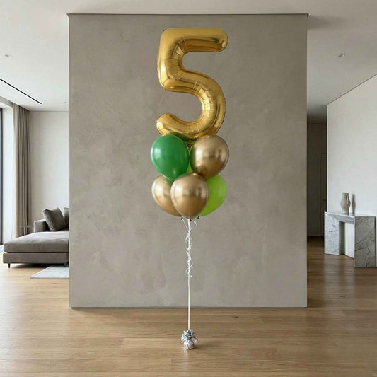 Gold and green balloons shaped like the number five in a modern living room.