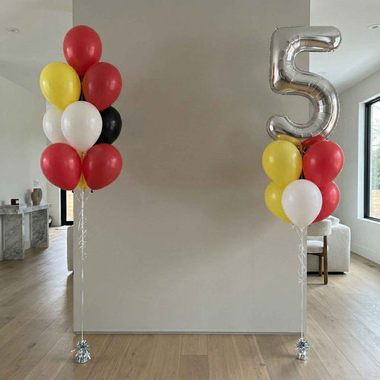 Colorful balloons with a large silver number '5' in a modern living room.
