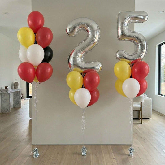 Decorative setup with number '25' balloons in a room.