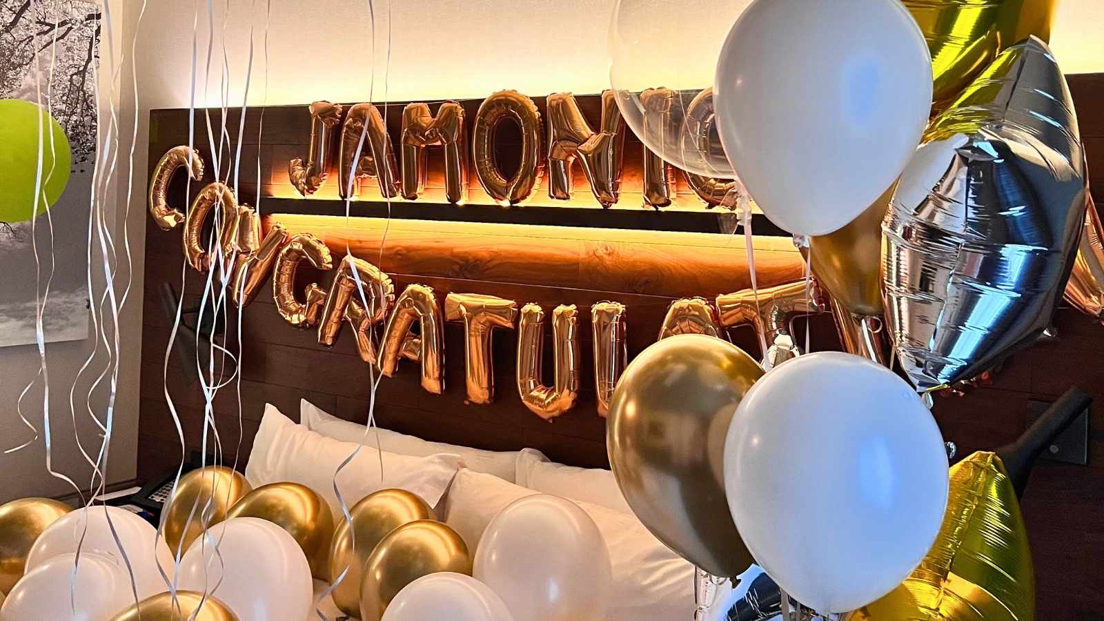 Load video: Luxury balloon bouquet number 26 displayed by a woman walking a runway, styled for an elegant celebration scene.