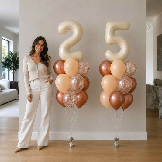 Woman standing next to large '25' balloons in a room with a couch and plant.