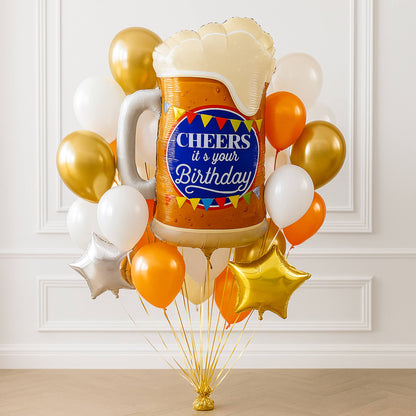 Balloon bouquet with a beer mug balloon and 'Cheers it's your Birthday' text against a white wall.