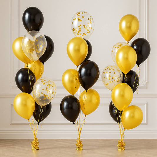 Two sets of balloons in black, gold, and clear with tassels on a neutral background