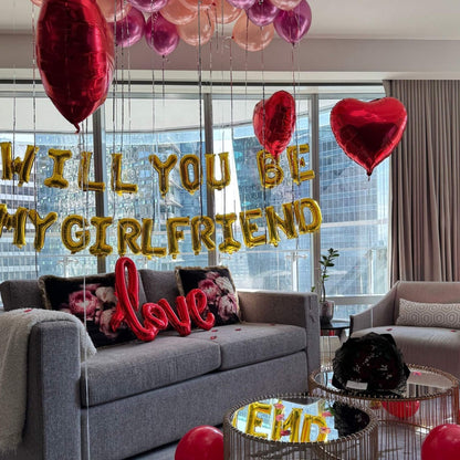Living room with balloons and 'WILL YOU BE MY GIRLFRIEND' question, with a cityscape view.