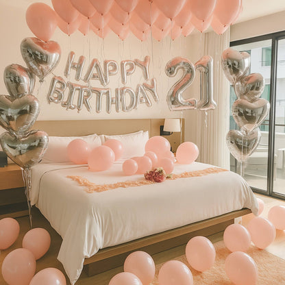 Decorated bedroom with 'Happy Birthday 21' balloons and pink balloons on a bed.