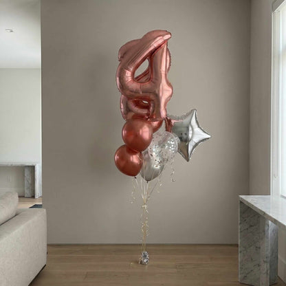 Decorative balloons shaped like the number '4' and a star in a living room setting.