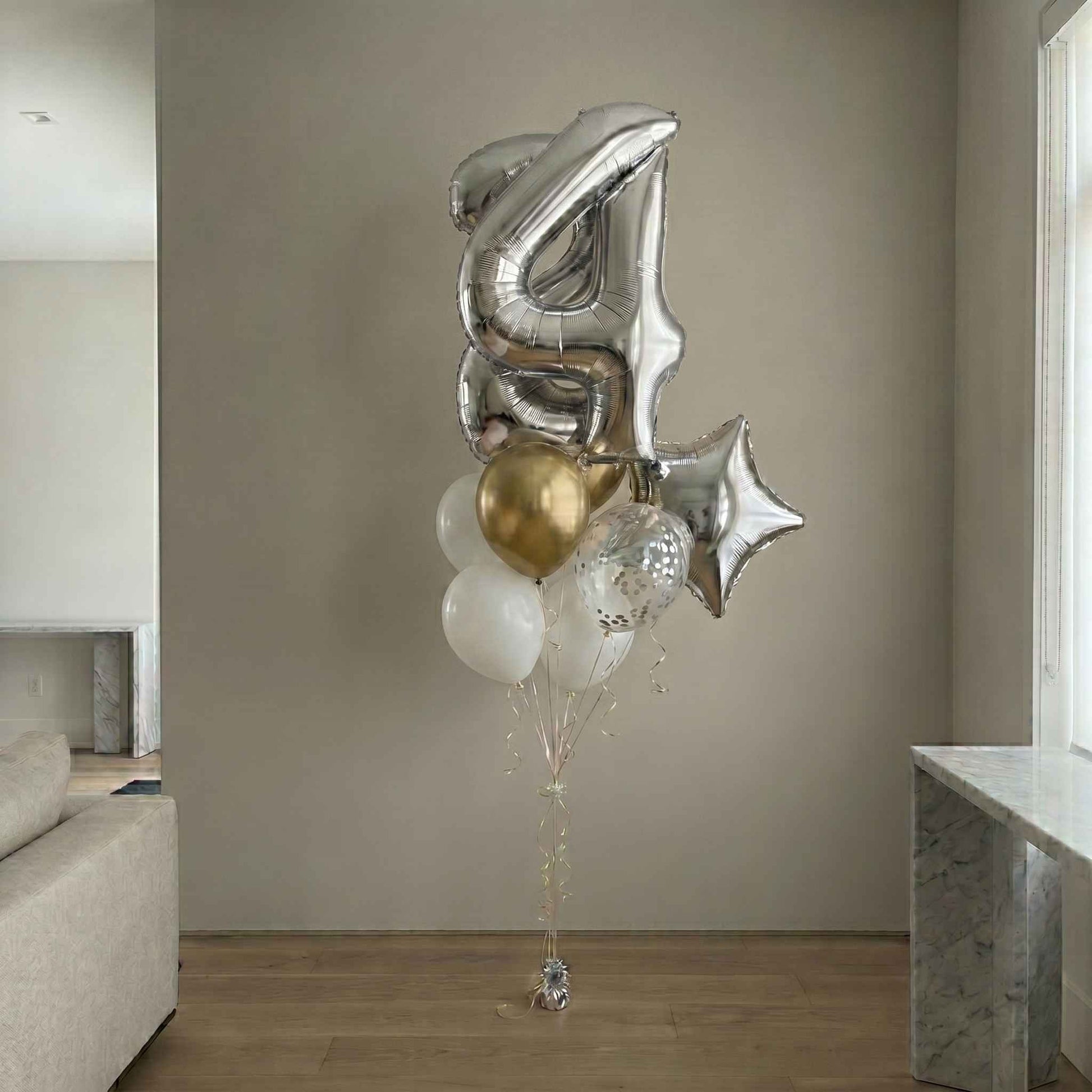 Decorative balloon bouquet with number '4' and star shapes in a living room setting.