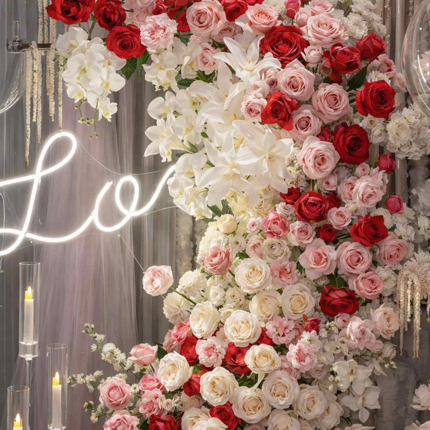 Floral arrangement with red, pink, and white flowers in front of a 'LOVE' neon sign.